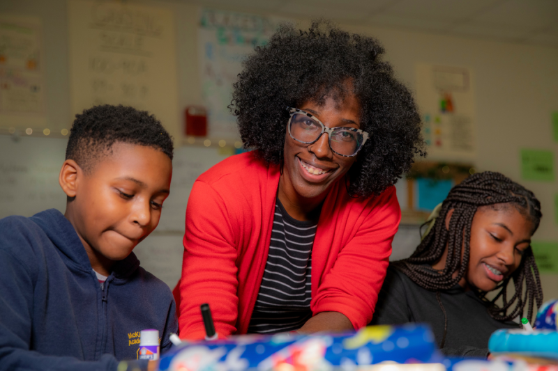 Denise Mallard, alumna of UL Lafayette's online Master of Education program, smiles as she works with two of her students.